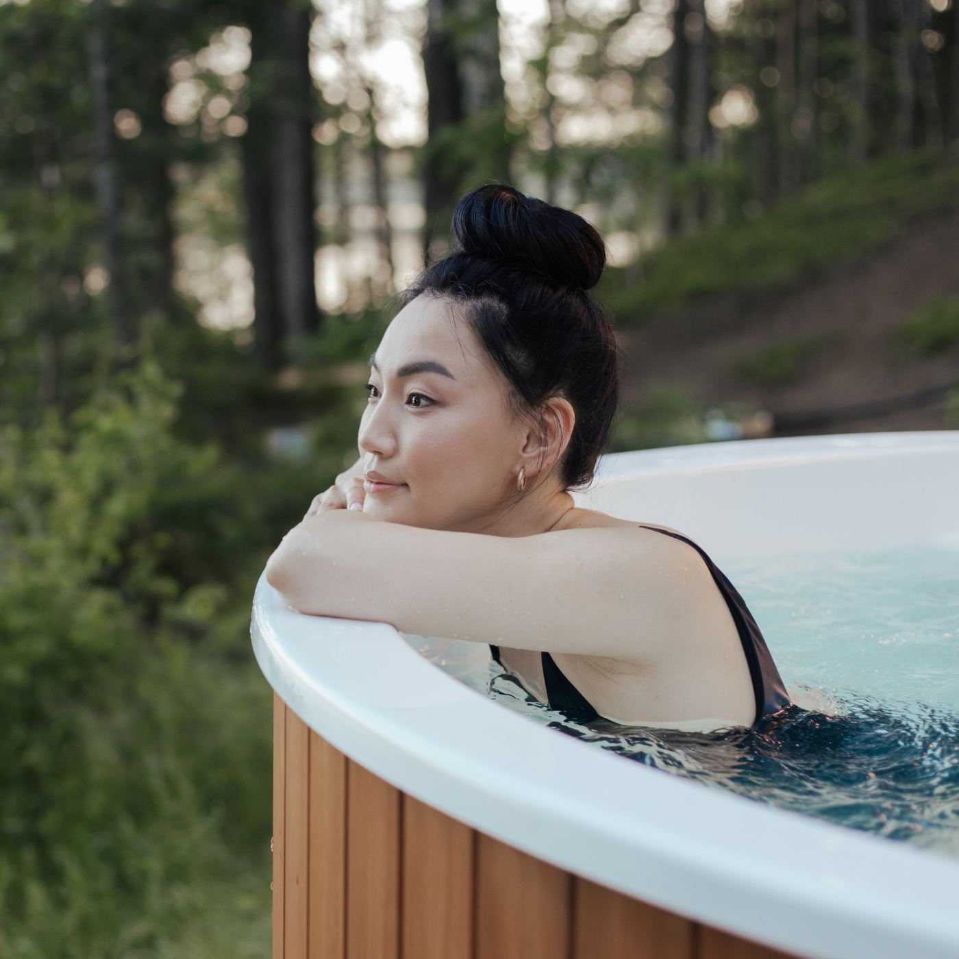 Frau entspannt im Whirlpool vor Wald