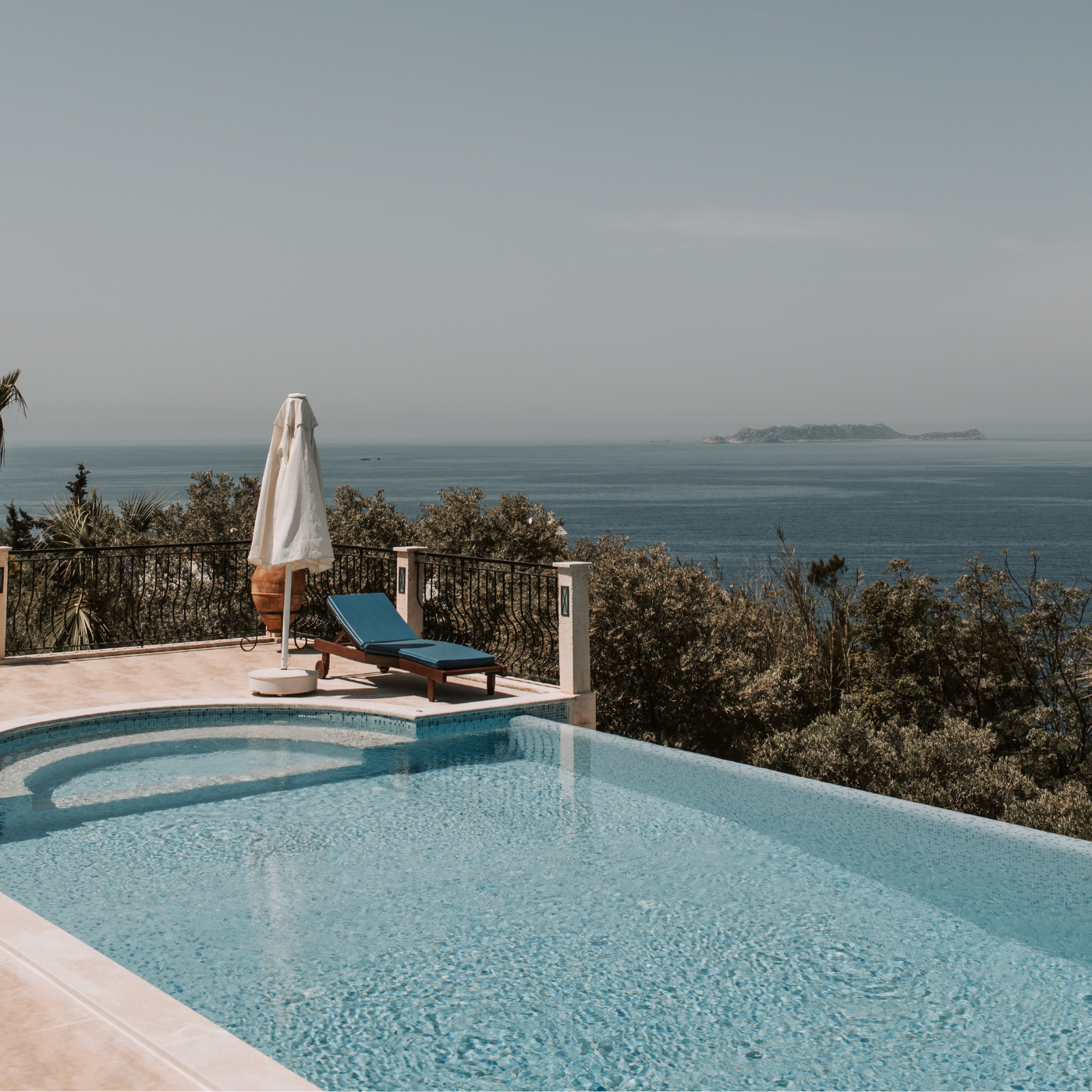 Blick auf Pool mit Treppe und auf das Meer