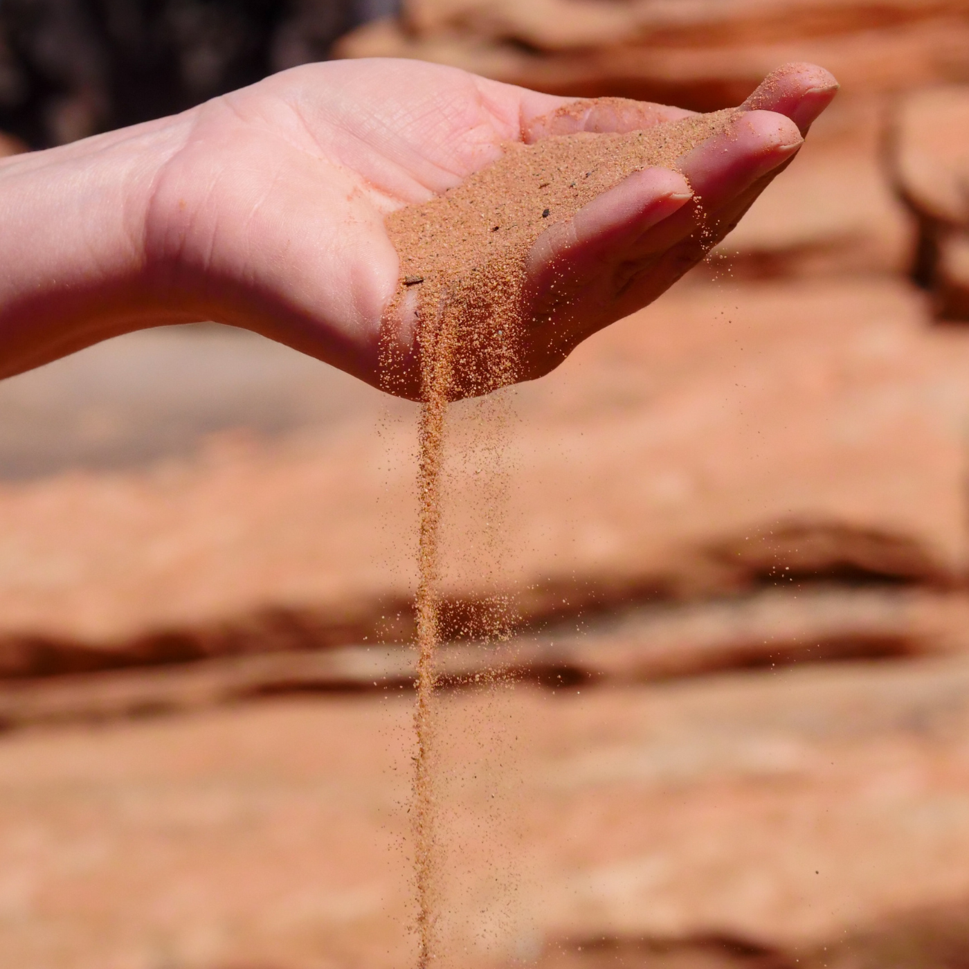 Hand mit Sand gefüllt der runterrieselt