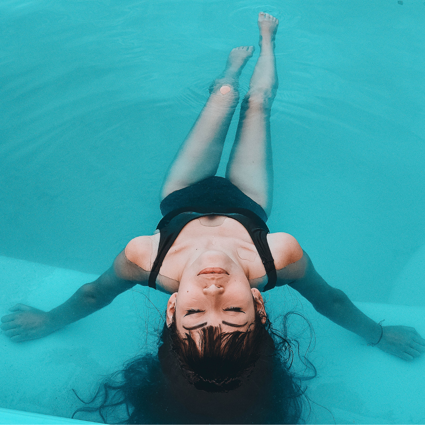 Eine Frau schwimmt auf dem Rücken im Wasser