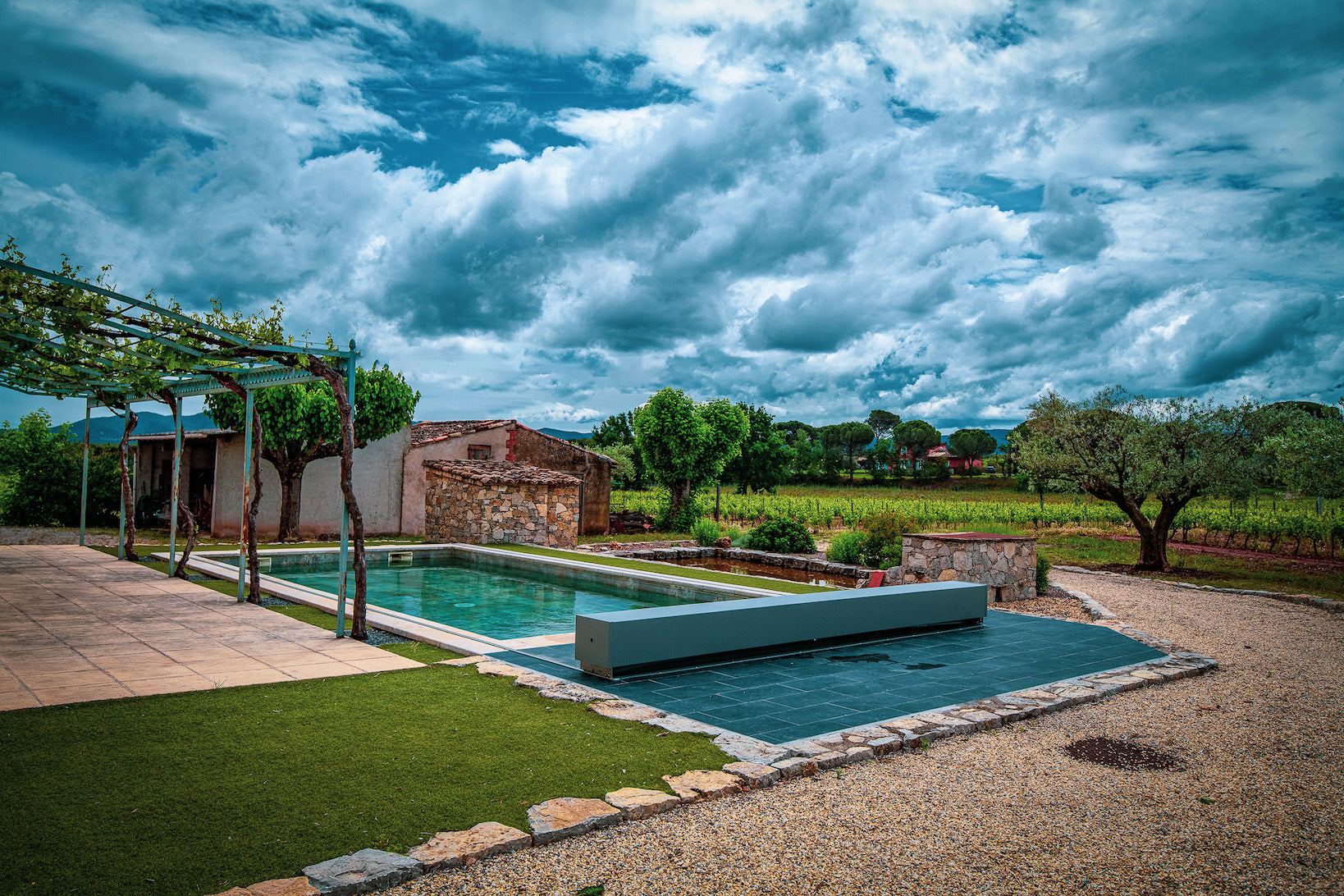 Pool in einem Weinbaugebiet mit Abdeckung und Haus im Hintergrund